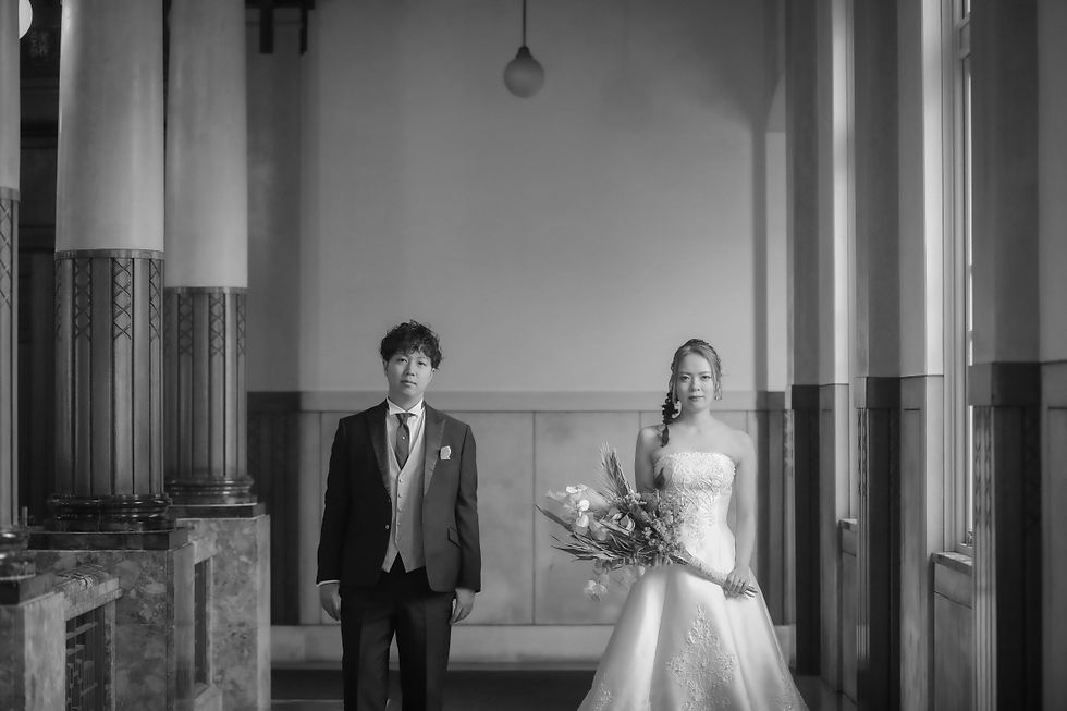 名古屋市政資料館のクラシックな建物内で、新郎新婦が並んで立つシンプルで洗練されたフォトウェディングの一コマ