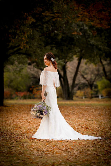名古屋庄内緑地公園で、紅葉を背にした美しいウェディングドレス姿の新婦が持つボタニカルブーケと共に秋の訪れを感じさせる前撮りフォト