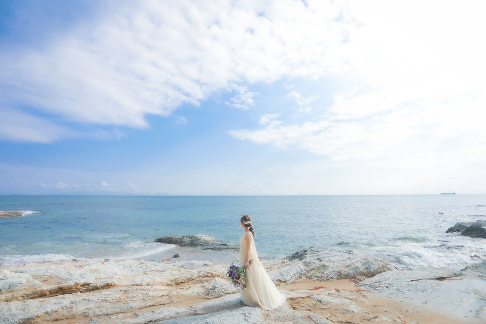 名古屋近郊の美しい海岸で、ウェディングドレスをまとった新婦が海を見つめる前撮りの一コマ