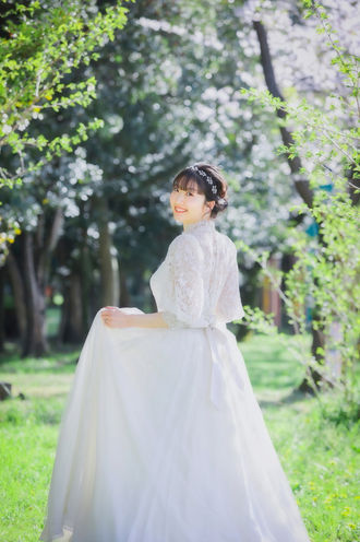 名古屋でのフォトウェディングの一シーン。新婦が輝く笑顔を見せ、自然の中で後ろ姿を見せる美しい瞬間