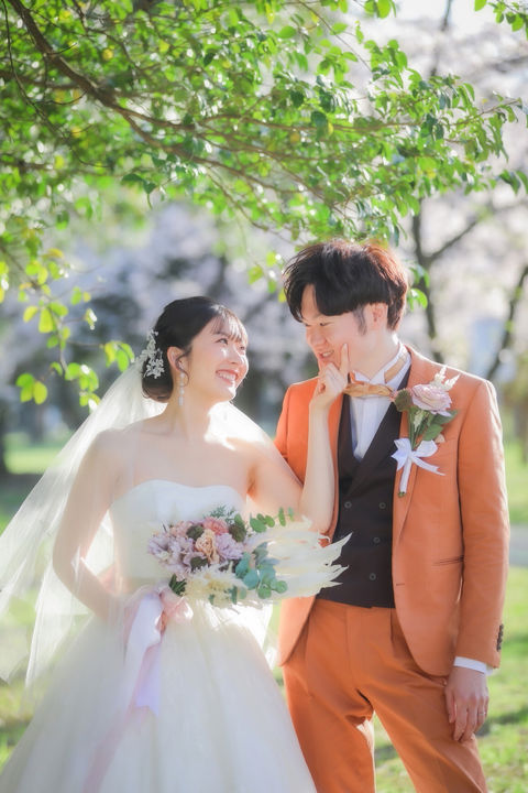 フォトウェディング名古屋の一コマ。新婦が新郎の頬に触れながら、笑顔で見つめ合う幸せな瞬間