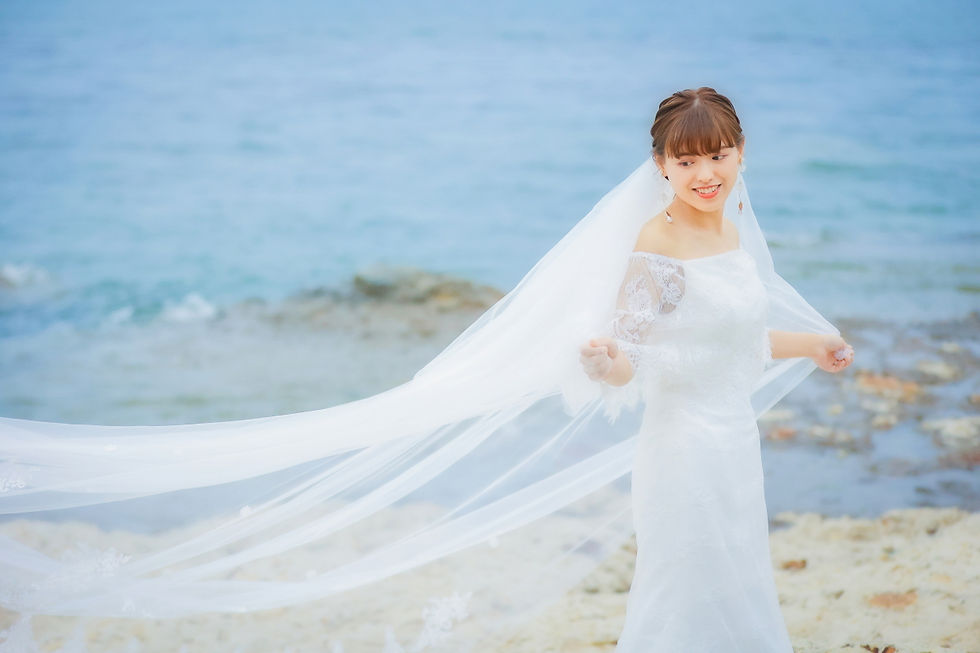 海辺でベールをなびかせる新婦、名古屋での前撮りフォトウェディングの一シーン