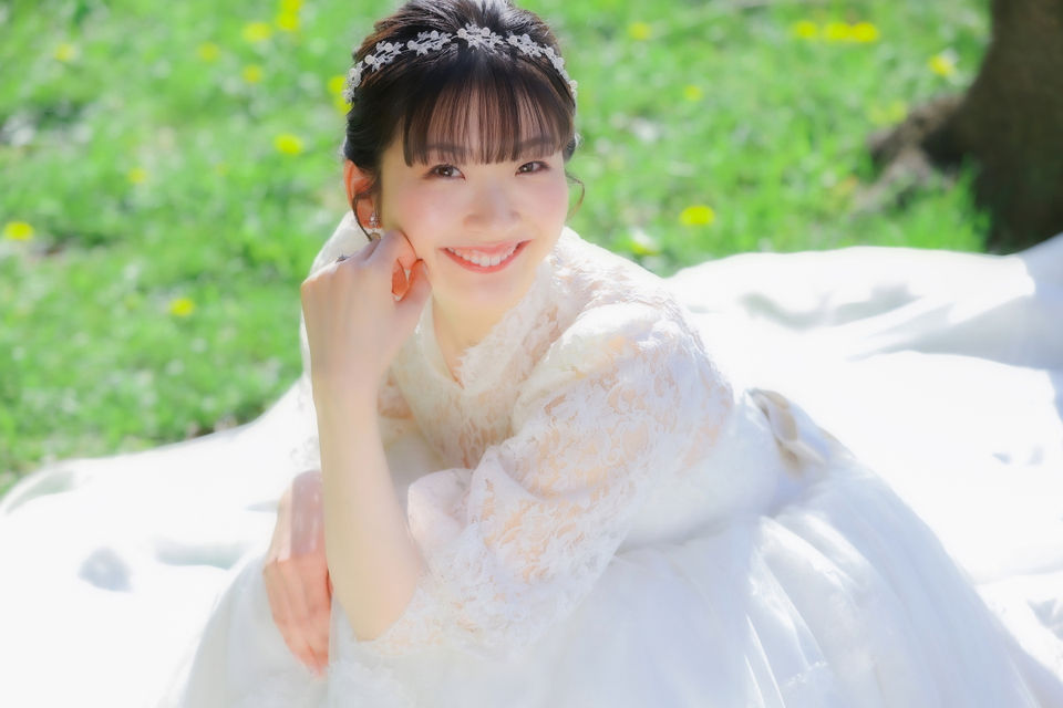 名古屋でのフォトウェディングのワンシーン。白いドレスを着た新婦が芝生の上で幸せそうに微笑む美しい瞬間