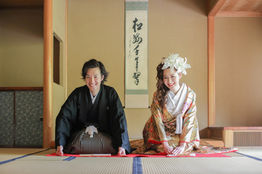 岡崎公園の伝統的な茶室での和装前撮り。黒羽織袴をまとった新郎と色彩豊かな着物の新婦が、岡崎公園の床の間で対面。日本のウェディングフォトの魅力を映し出す一枚