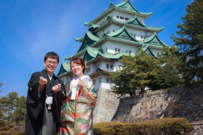 名古屋で和装前撮りフォトウェディングを行なった新郎と新婦。名古屋城と青空を背景に和装姿で楽しげな笑顔の二人を捉えたウェディングフォト。