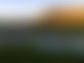 Winery set among vines with mountains glowing in the sunset behind.