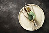 white-craft-plate-cutlery-green-plants-black-table.jpg