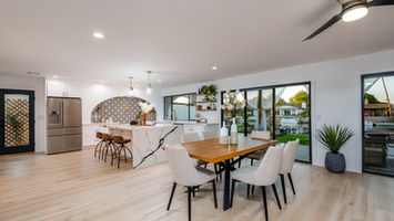 Modern dining room with table, chairs, and marble island featuring white walls. phoenix real estate photographer