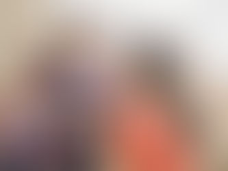 Two women chatting with mugs of tea.