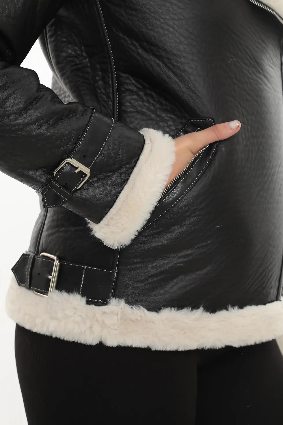 Thumbnail: A woman wearing a black shearling jacket with white fur interior, close up view — By Kani.