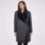 A woman wearing a black shearling coat, front view