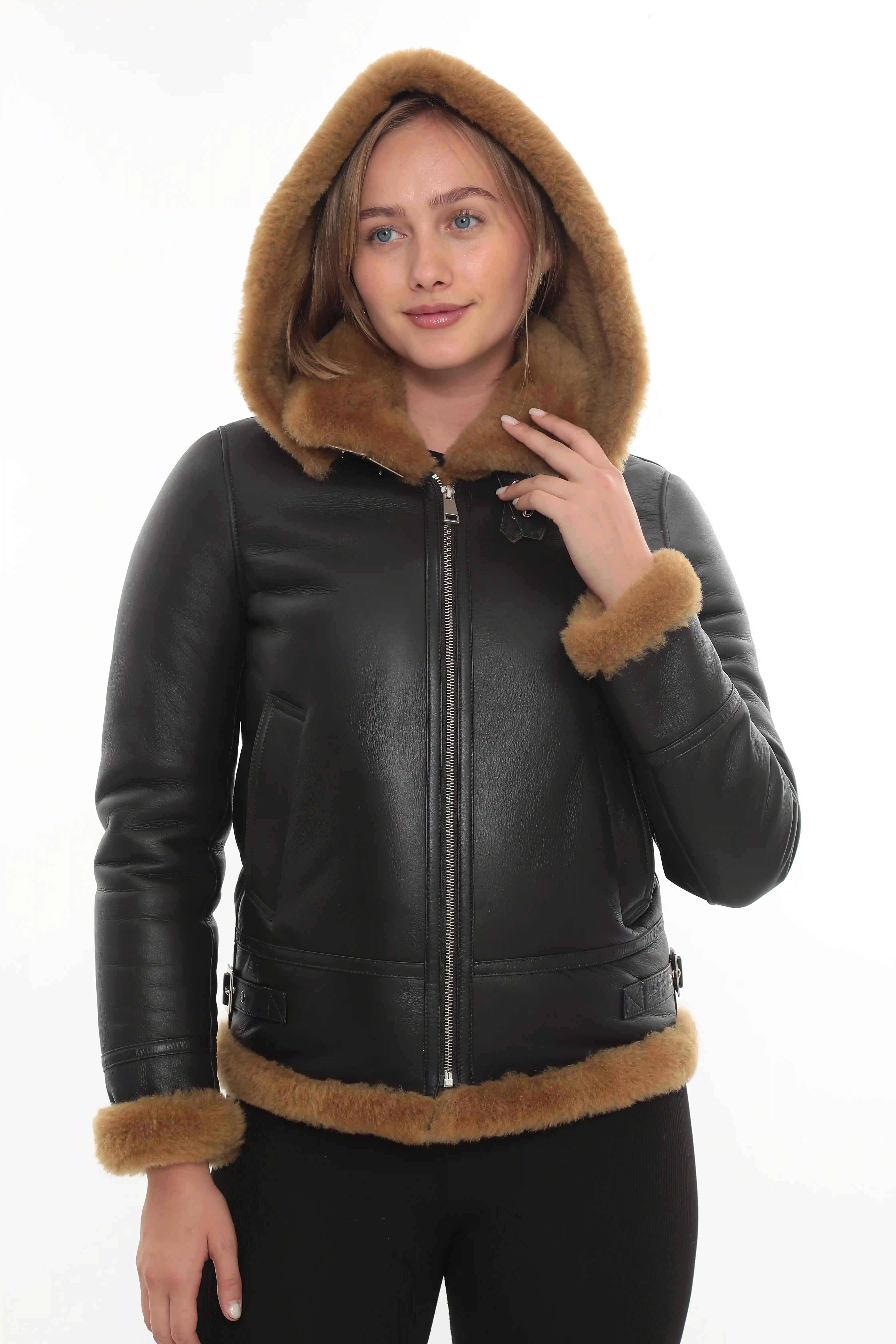 A woman wearing a brown hooded shearling jacket, front view - By Kani.