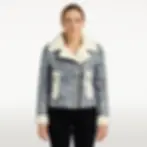 A woman wearing a black and white sheepskin shearling jacket, front view