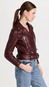 A woman wearing a burgundy leather jacket.
