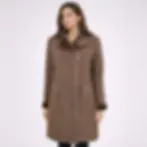A woman wearing a brown shearling coat, front view