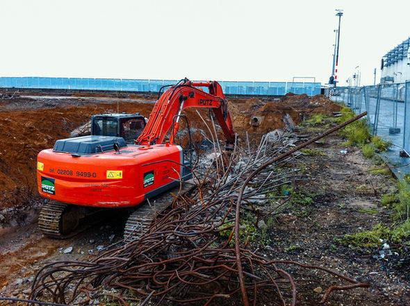 Bagger mit sortiertem Metall- und Abbruchmaterial auf einer Baustelle