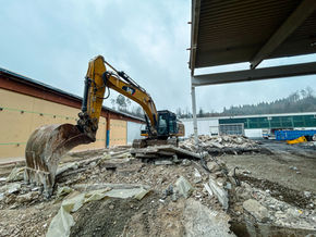 Bagger bei Abbruch- und Sortierarbeiten von Betonmaterial