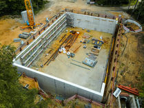 Rohbau eines rechteckigen Regenrückhaltebeckens aus Beton im Tiefbau mit Schalung und Baustelleneinrichtung