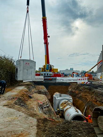 Versetzen eines Betonfertigteils mit Mobilkran im Tiefbau für ein Kanal- oder Schachtbauwerk