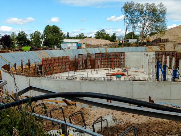 Rohbau eines runden Regenrückhaltebeckens im Tiefbau mit Schalung und Bewehrung auf einer Baustelle