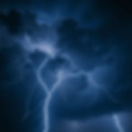 lightning with storm and grey clouds blue and white with black background.jpg