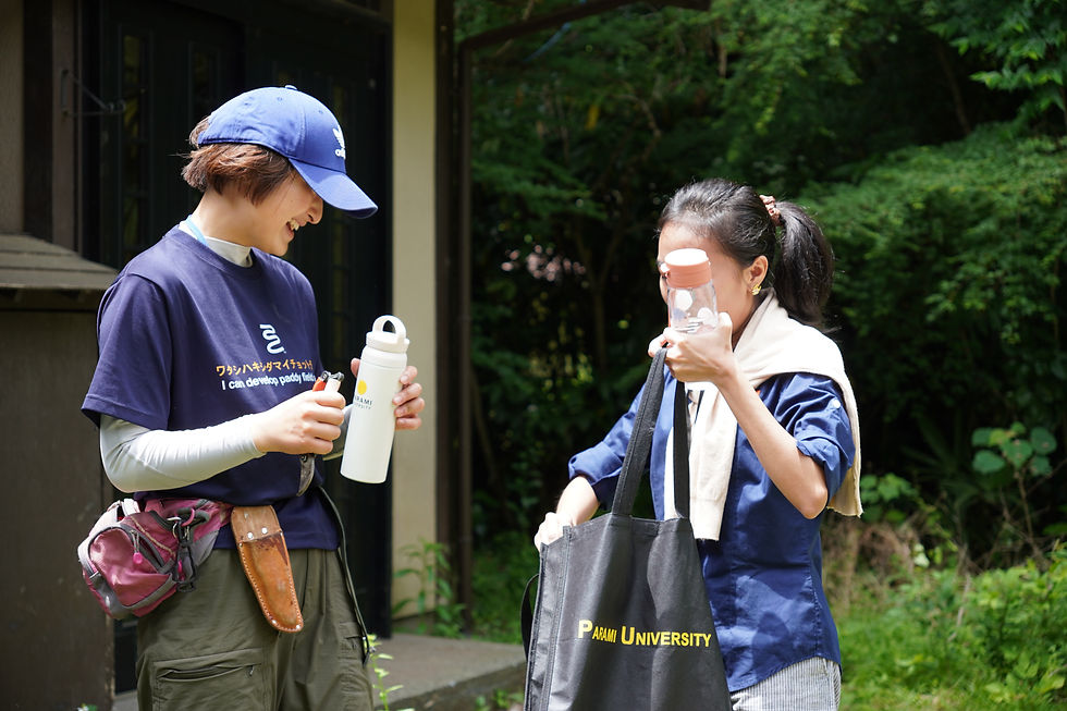 A Parami student sharing a gift with ICU students at ICU's wasabi field