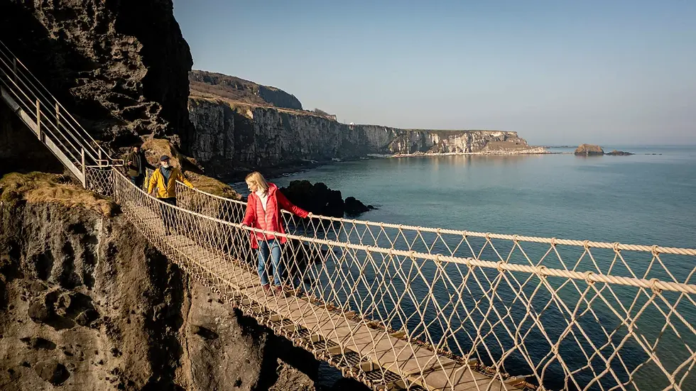 visitors walking across Carrick-a-Rede Rope Bridge in Ireland