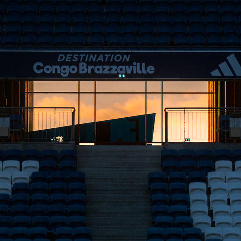 Intérieur du stade, panneau lumineux DESTINATION Congo Brazzaville au coucher du soleil.