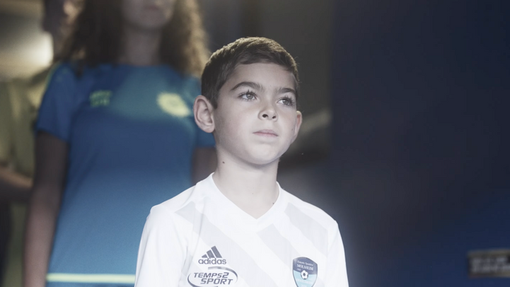 Jeune footballeur concentré en maillot Adidas GENERATION FOOTBALL dans tunnel.