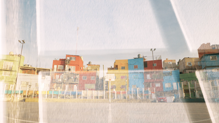 Façades colorées et vives d'un quartier sous ciel clair, reflet lumineux.