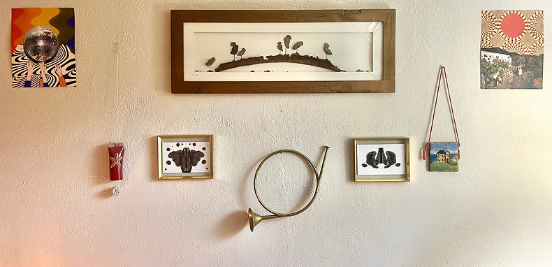 Wall of artwork and instruments symbolizing healing, diversity, and creativity in therapy.