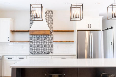Modern kitchen with island, white cabinets, and patterned tile