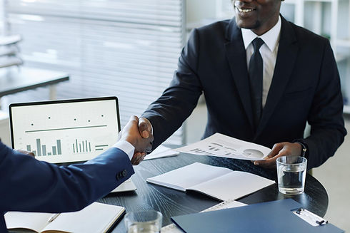 close-up-two-impersonal-business-men-shaking-hands-across-meeting-table-office-after-negot