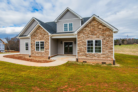 New house with stone and siding, green lawn