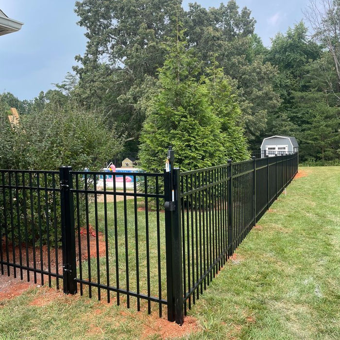 Black aluminum fence with gate in a backyard