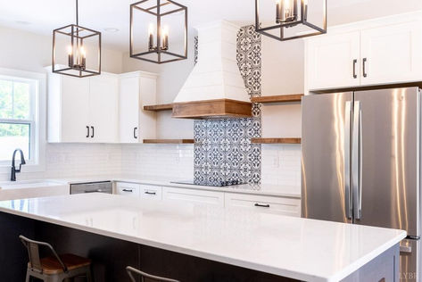 Modern kitchen with island, white cabinets, patterned backsplash