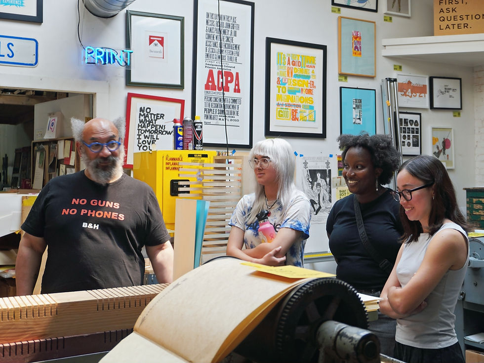 (From left) Rick shows Mai, Nia, and Emi the printing press