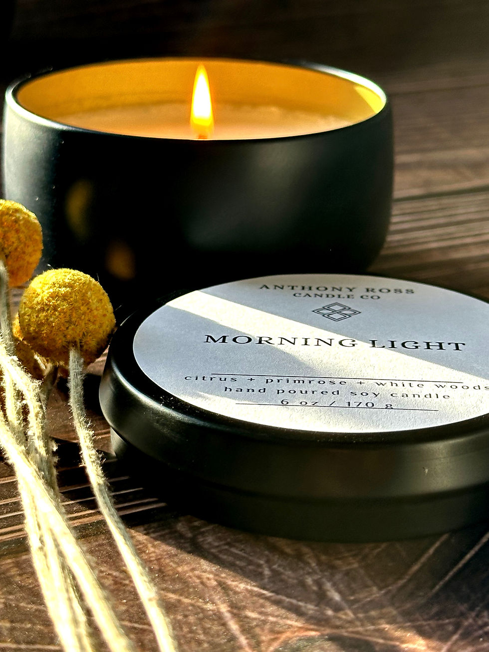 a burning candle on a dark wood surface