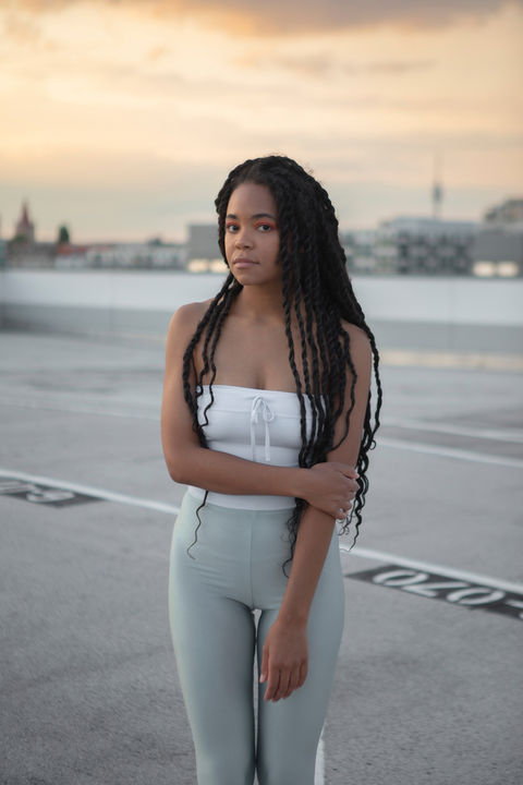 Junge Frau die im Sonnenuntergang für ein Portrait posiert