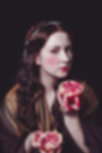 Foto im Renaissance -Stil mit einer Frau die einen Granatapfel in Händen hält