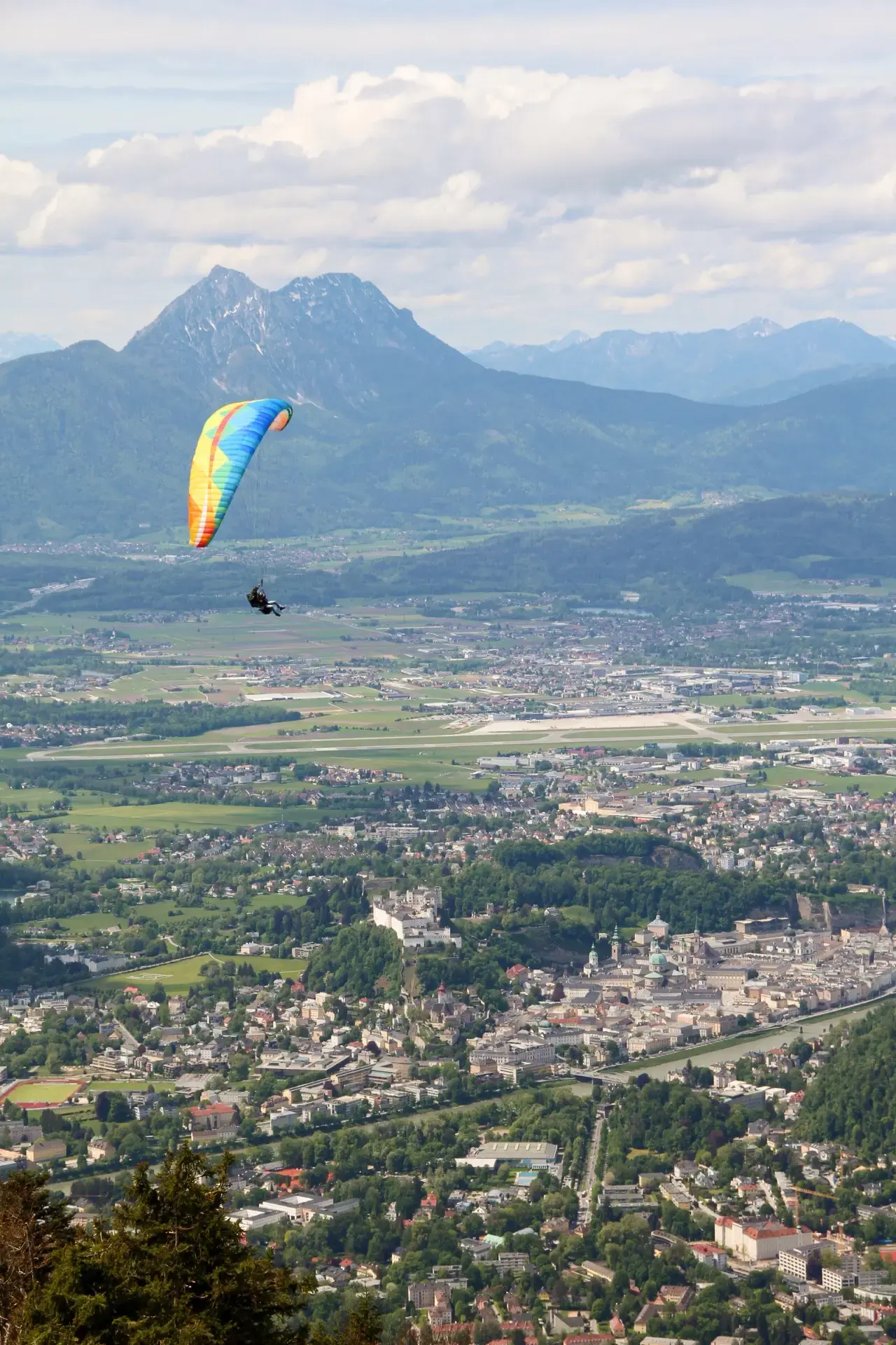 Flying High above Salzburg city with Alpine mountain in the background