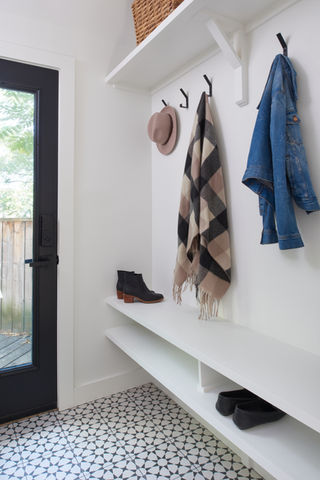 White mudroom bench with black and white patterned tile floor