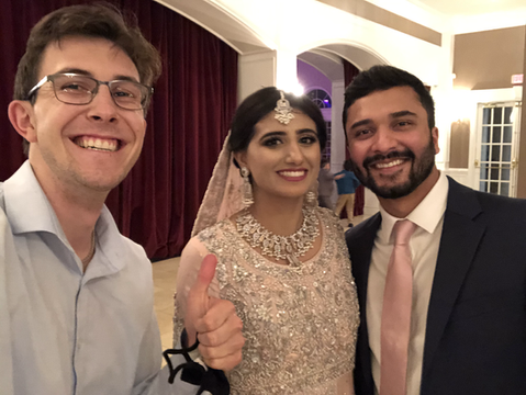 Couple on wedding outfits posing while smiling next to Arazo crew
