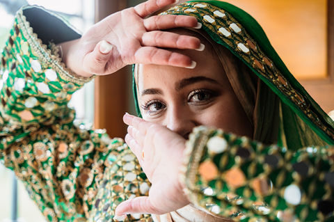 Bride with traditional clothes showing her hands and eyes