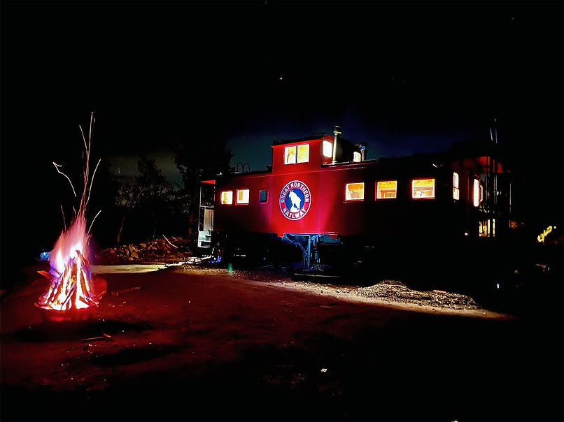 The caboose illuminated under th Colorado night sky.