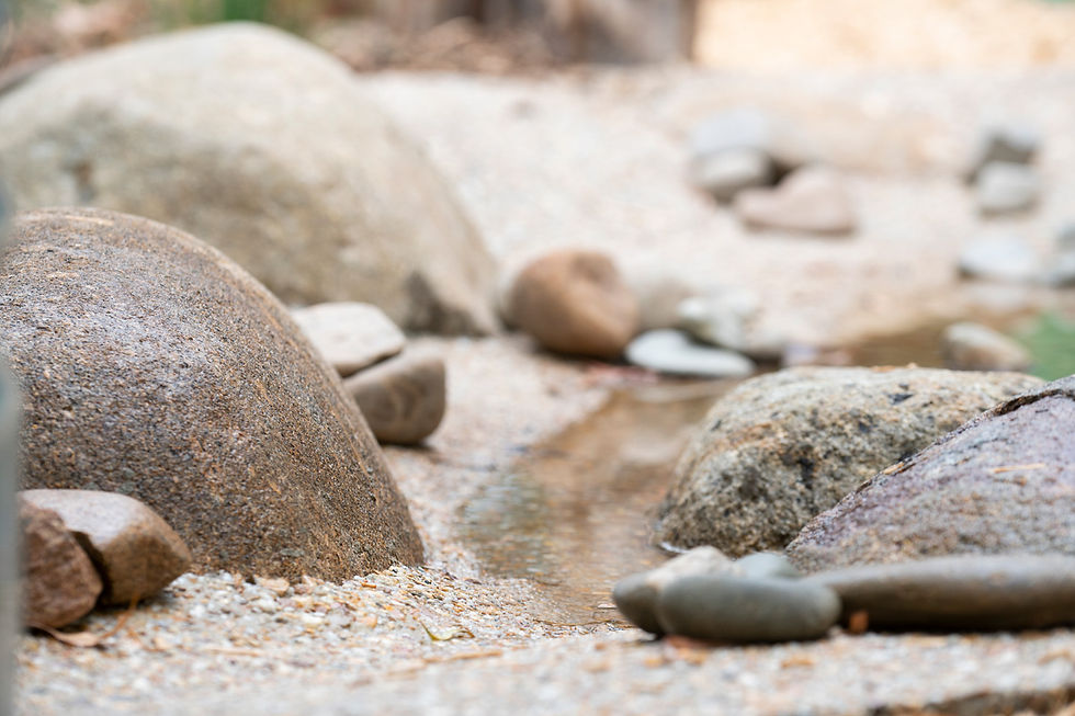 A passive water-play feature with smooth river stones