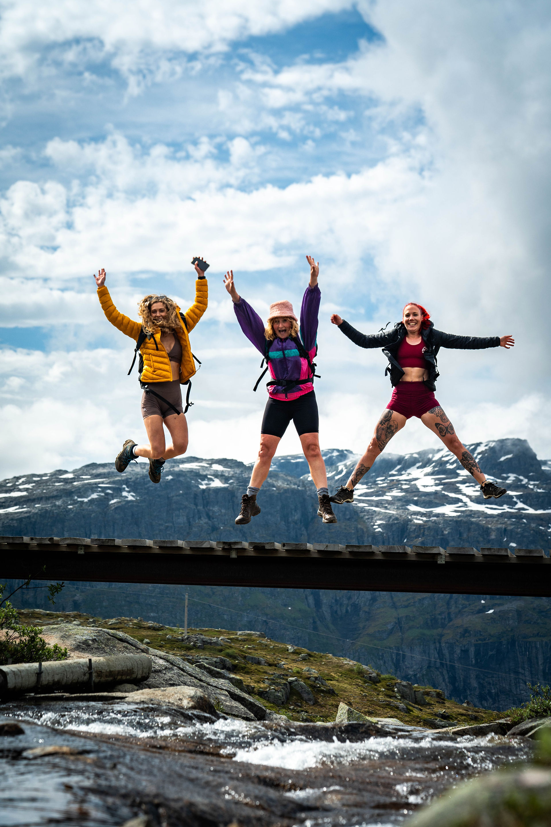 Hikers jumping on a bridge in Norway
