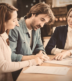 young-couple-agreeing-on-matter-signing-document-with-a-family-solicitor
