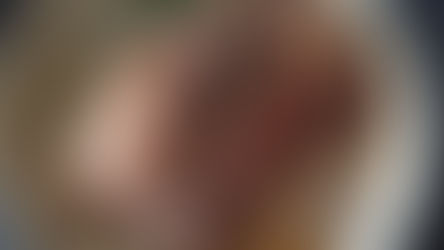 Trussed and seared pork with whole black peppercorns and rosemary braising in liquid in a large pot. Juicy and browned with herbs visible, creating a warm and savoury atmosphere. The setting is a stove top.