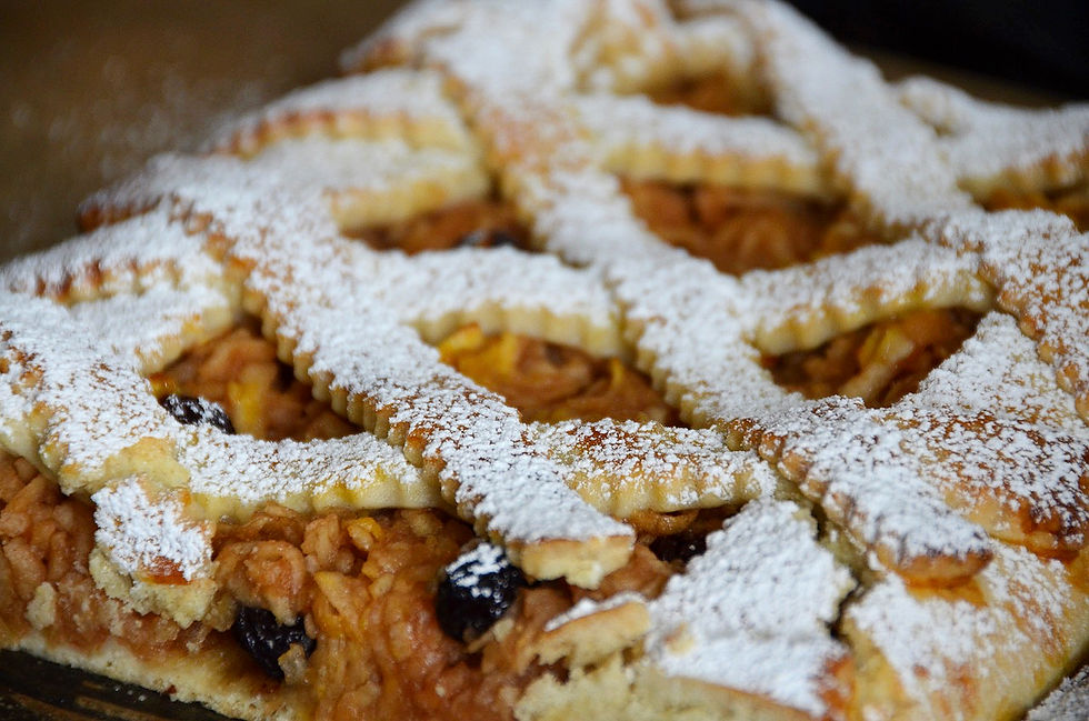 Close-up of a apple baked pie with a lattice crust, dusted with powdered sugar. The filling is grated apple with raisins. Warm and inviting.